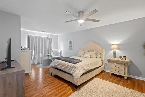 a spacious bedroom with a bed and a flat screen television