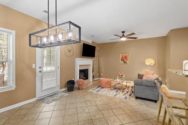 a living room with furniture a fireplace and a chandelier