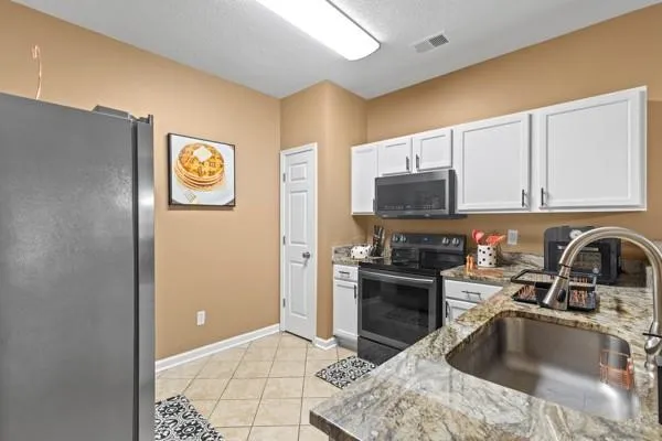 a kitchen with stainless steel appliances granite countertop a refrigerator a stove top oven a sink and dishwasher