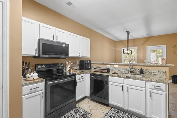 a kitchen with sink a stove and microwave