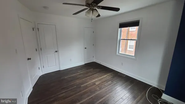 an empty room with wooden floor and closet