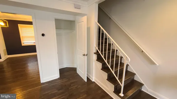 a view of a hallway with wooden floor and stairs