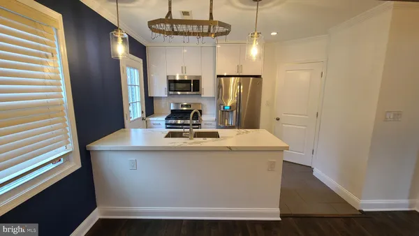 a view of kitchen with stainless steel appliances granite countertop cabinets and wooden floor