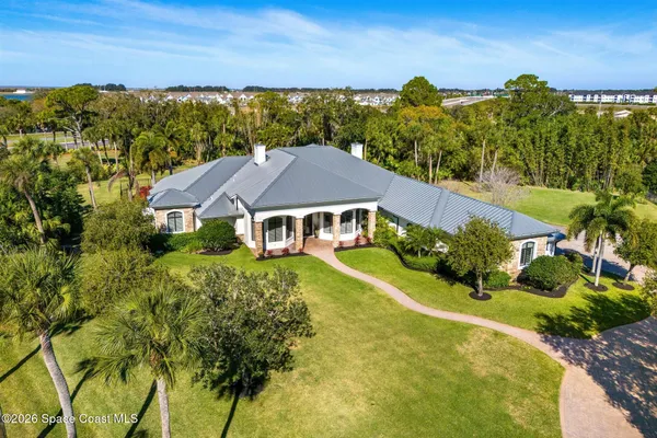an aerial view of house with yard swimming pool and ocean view
