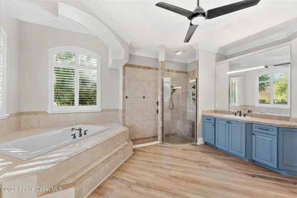 a large white kitchen with stainless steel appliances granite countertop a stove a sink dishwasher and white cabinets with wooden floor