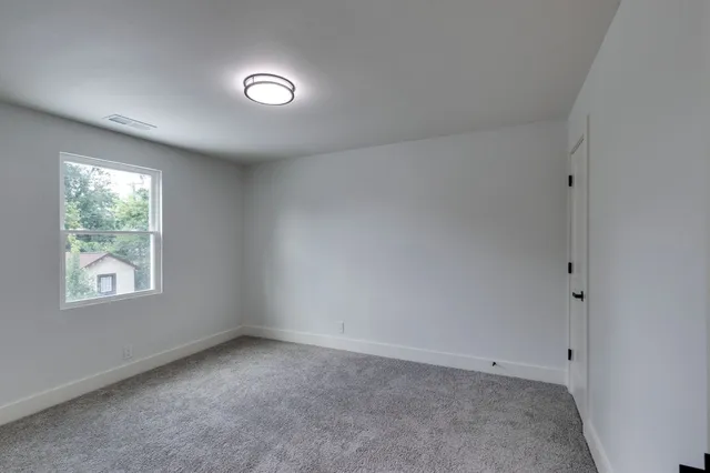 an empty room with closet area and mirrors