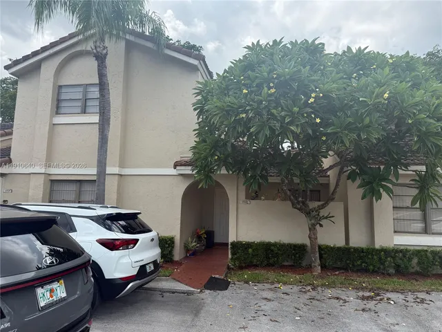 a car parked in front of a white house