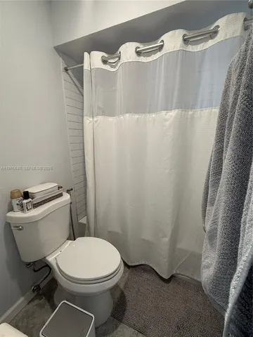 a white toilet sitting next to a white sink