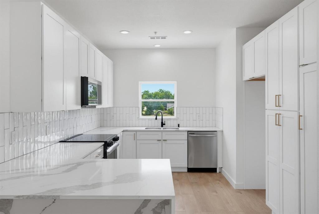 504 South O Connor Road Irving, TX 75060 - Photo 3 of 23 Modern kitchen featuring white shaker cabinetry, stainless steel appliances, and wood-finish flooring