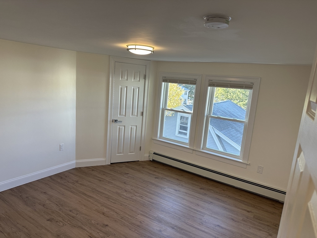 367 Concord Avenue, Unit 3 Cambridge, MA 02138 - Photo 5 of 7 an empty room with wooden floor and windows