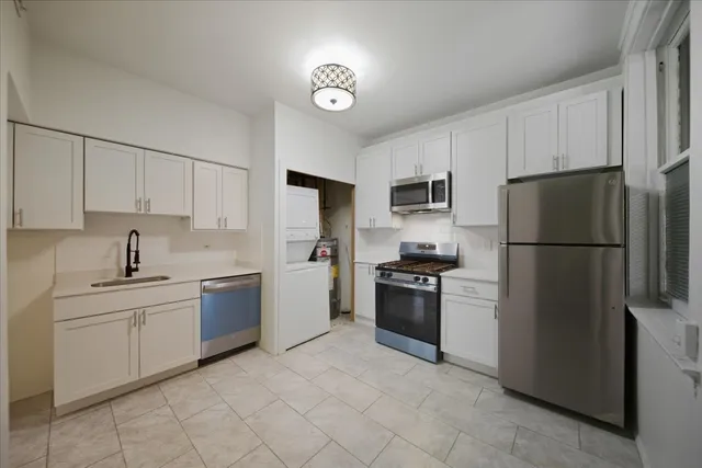 a kitchen with stainless steel appliances granite countertop a refrigerator sink and stove