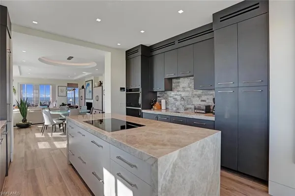 a large kitchen with stainless steel appliances lots of counter space and a sink