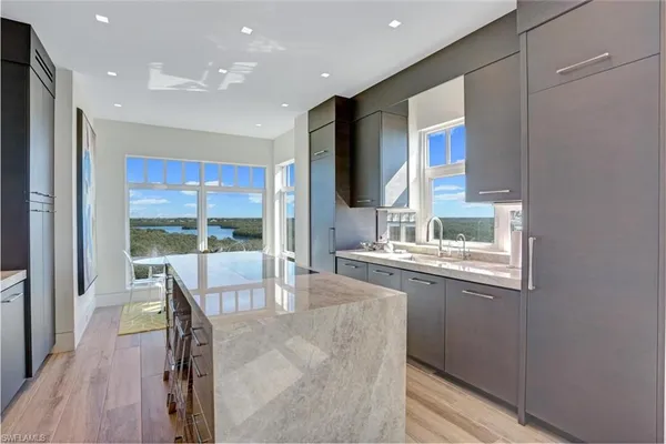 a kitchen with granite countertop a sink and a refrigerator