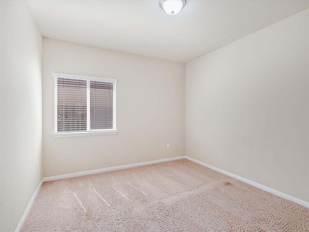 141 Serrano Street Georgetown, TX 78628 - Photo 12 of 19 Well-lit and ready for personalization, this bedroom offers comfortable carpet and window treatments.