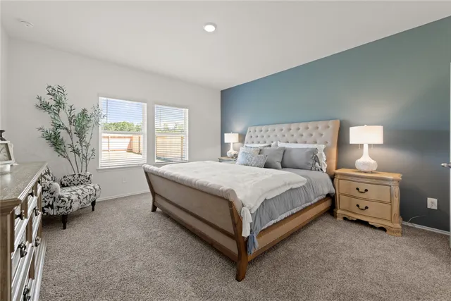 a bed sitting in a bedroom next to a window with lamp