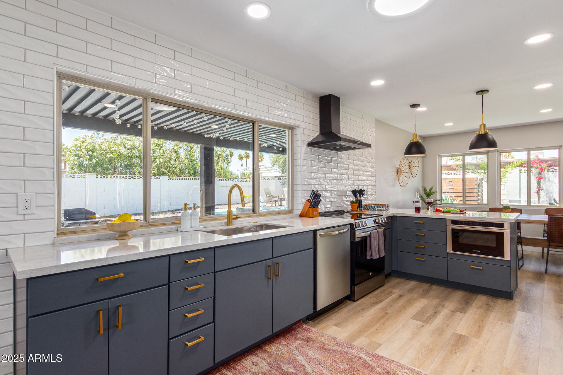 6612 East Presidio Road Scottsdale, AZ 85254 - Photo 6 of 54 a kitchen with lots of counter top space and wooden floor