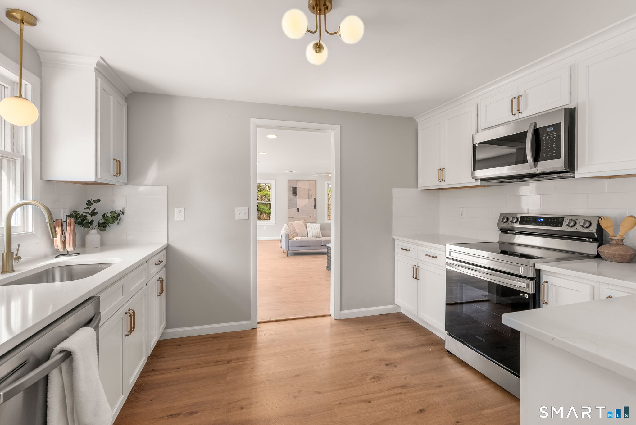 89 Bradway Road Stafford, CT 06076 - Photo 9 of 39 a kitchen with stainless steel appliances granite countertop a sink dishwasher a stove and a microwave oven with white cabinets