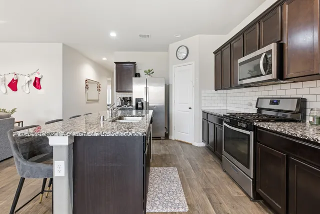 a living room with furniture a chandelier and a dining table