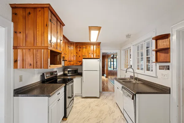 a kitchen with granite countertop a sink a stove and refrigerator