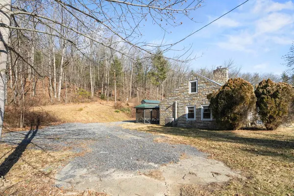 a view of a white house with a yard and large trees