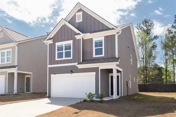 a view of a house with a yard and garage