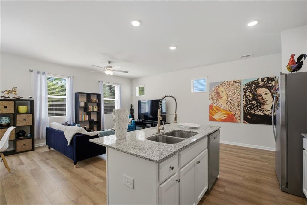1242 Riverstone Road Jonesboro, GA 30238 - Photo 12 of 38 a view of kitchen island with stainless steel appliances granite countertop sink stove and living room