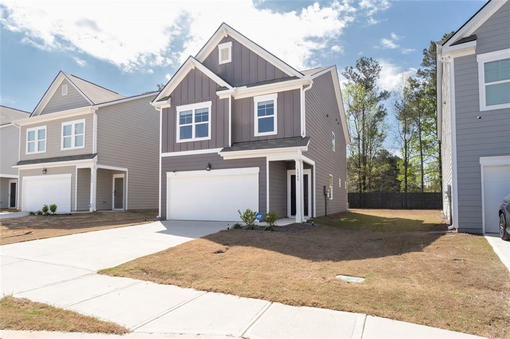 1242 Riverstone Road Jonesboro, GA 30238 - Photo 2 of 38 a front view of a house with a yard and garage