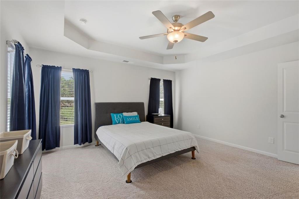 1242 Riverstone Road Jonesboro, GA 30238 - Photo 21 of 38 a bedroom with a large bed chandelier and a large window
