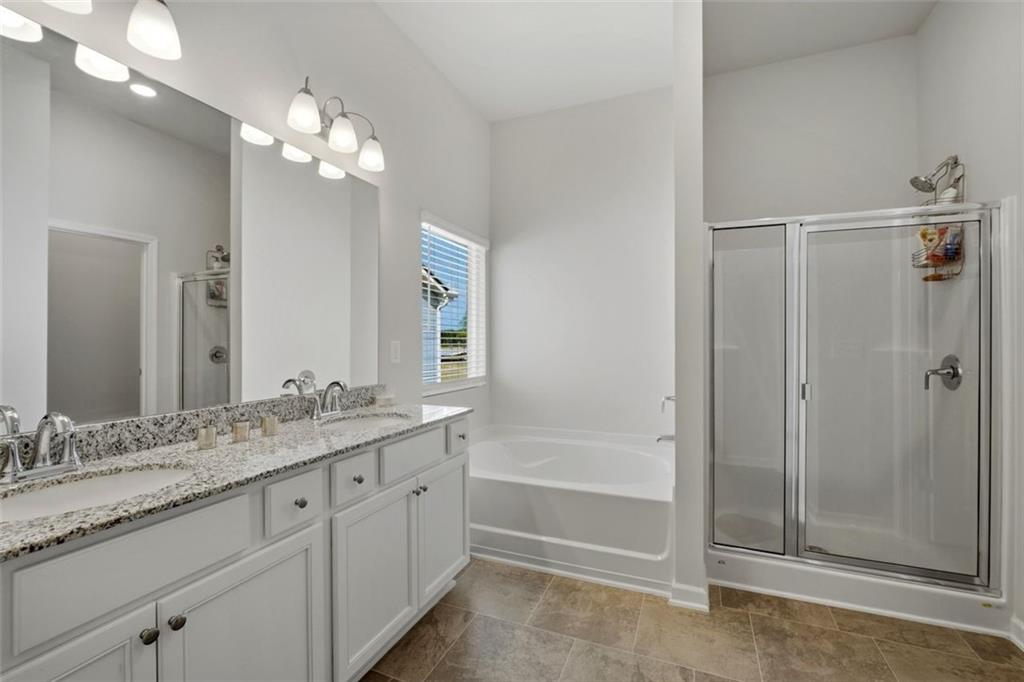 1242 Riverstone Road Jonesboro, GA 30238 - Photo 24 of 38 a bathroom with a granite countertop sink a mirror and a bathtub
