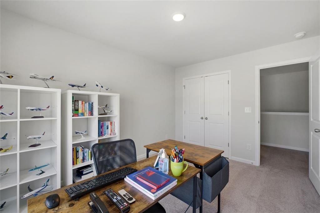 1242 Riverstone Road Jonesboro, GA 30238 - Photo 27 of 38 a room with furniture a rug and a book shelf