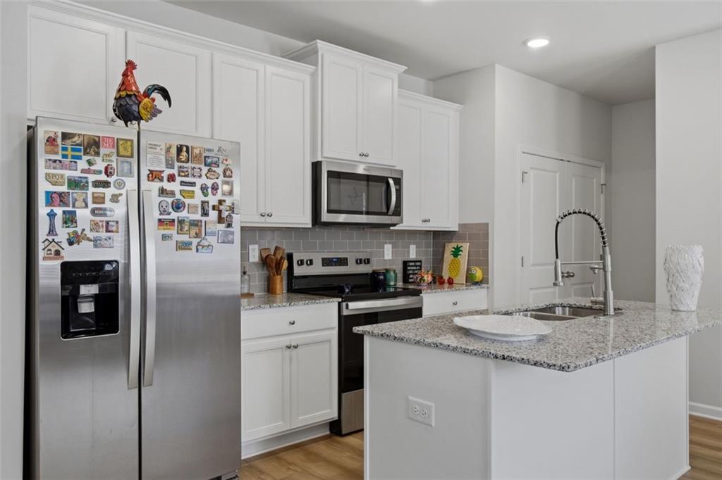 1242 Riverstone Road Jonesboro, GA 30238 - Photo 9 of 38 a kitchen with stainless steel appliances granite countertop a refrigerator and a stove top oven