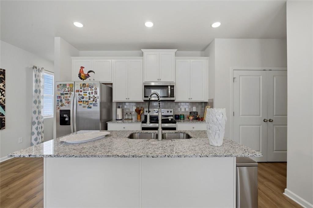 1242 Riverstone Road Jonesboro, GA 30238 - Photo 10 of 38 a kitchen with stainless steel appliances granite countertop a sink refrigerator and cabinets