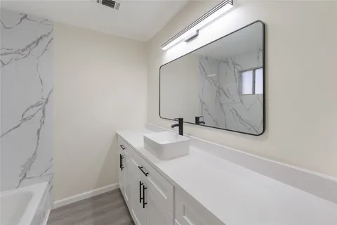 a bathroom with a sink vanity and mirror