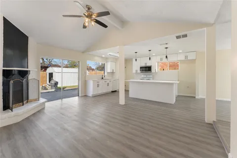 a view of a kitchen with furniture and wooden floor
