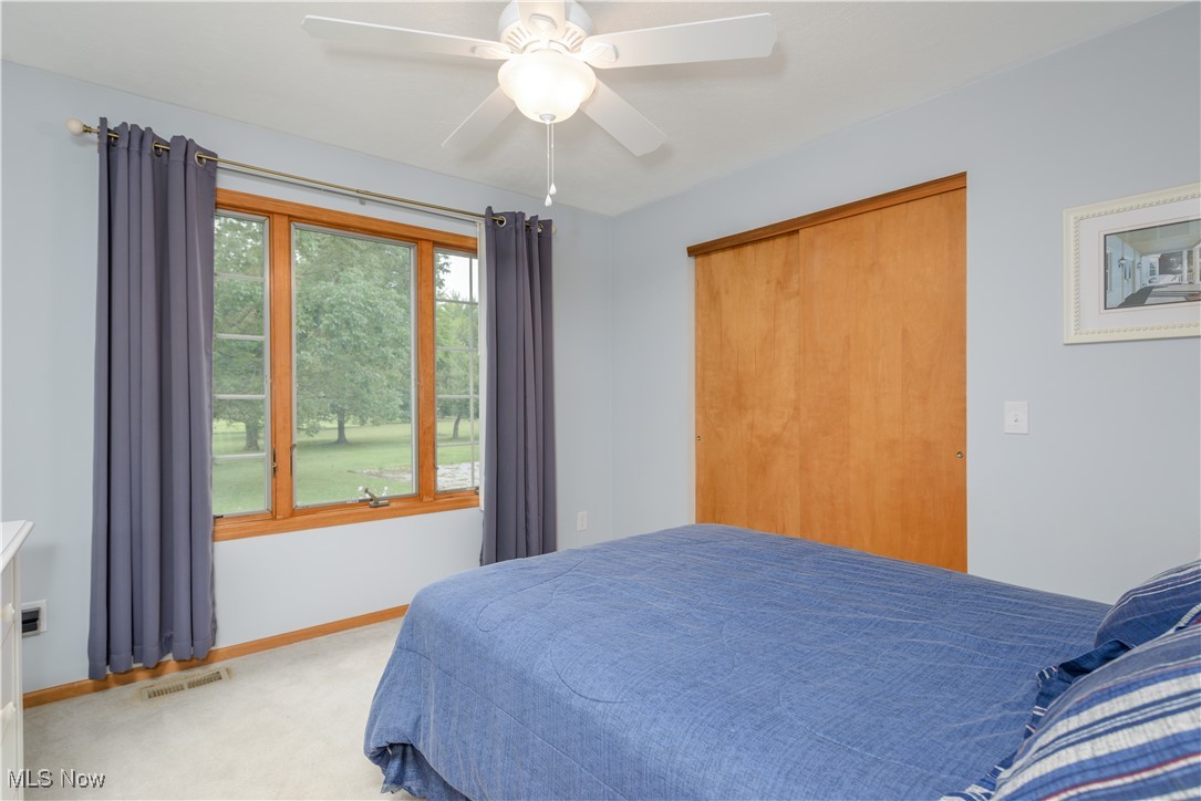 1435 Industry Road Atwater, OH 44201 - Photo 25 of 48 Carpeted bedroom featuring ceiling fan and a closet