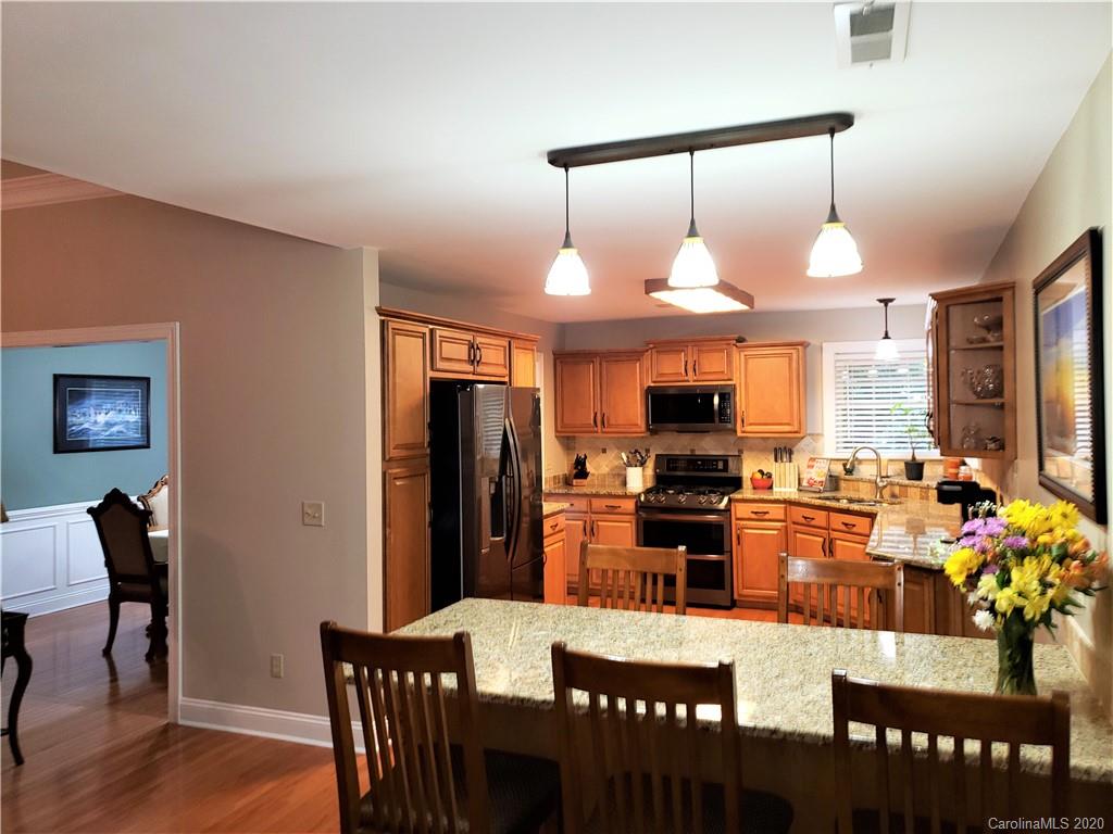 121 Spring Branch Road Fort Mill, SC 29715 - Photo 9 of 17 a kitchen with a dining table chairs stainless steel appliances and cabinets