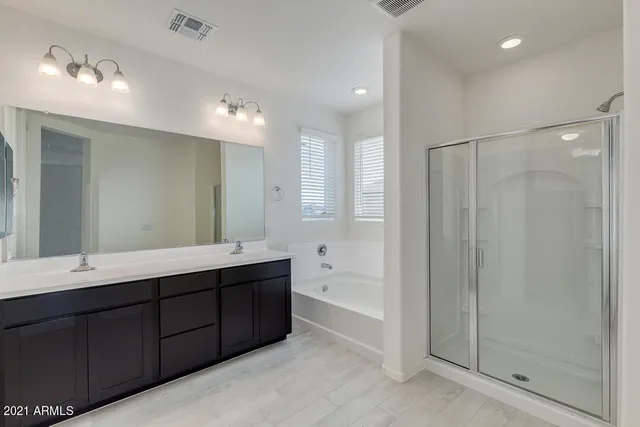 a bathroom with double vanity sinks and a mirror