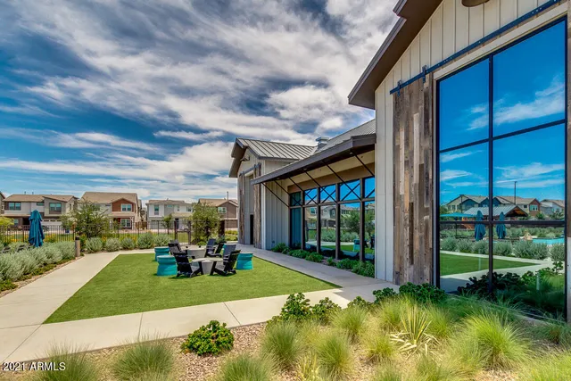 a view of a patio with table and chairs potted plants and floor to ceiling window