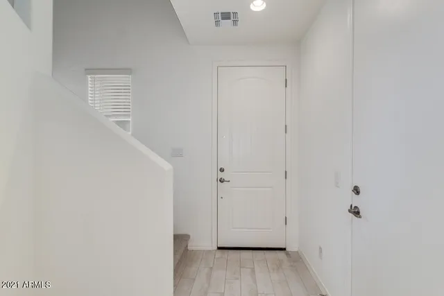 a view of a hallway with wooden floor and closet