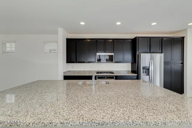 a kitchen with stainless steel appliances a refrigerator and a stove top oven