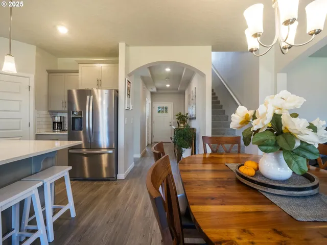 a kitchen with stainless steel appliances granite countertop dining table chairs and chandelier