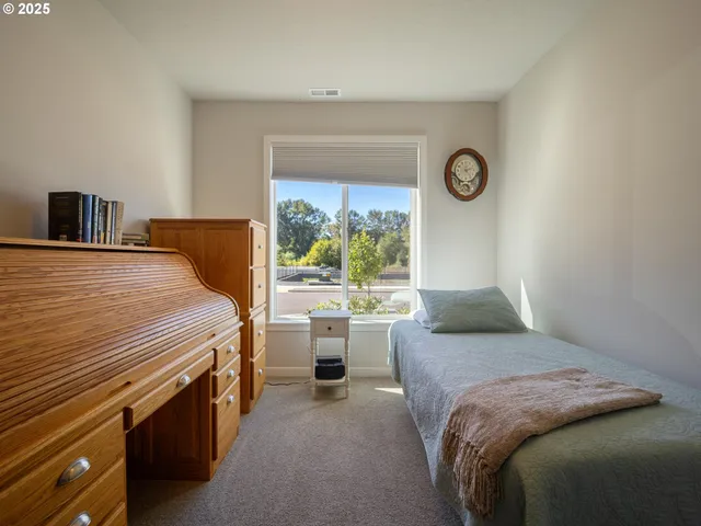 a bedroom with a bed and a large window