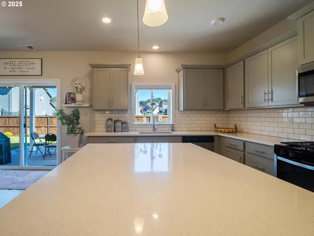 a large kitchen with lots of counter space a sink and appliances