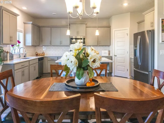 a kitchen with stainless steel appliances kitchen island granite countertop a dining table and chairs