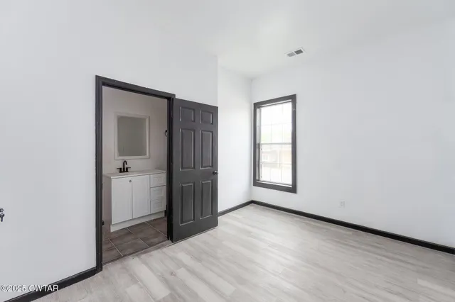 an empty room with windows and closet