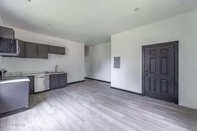 a large kitchen with a wooden floor and stainless steel appliances