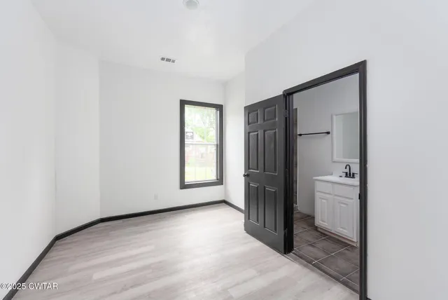 an empty room with windows and closet