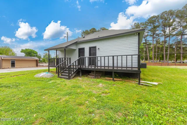 a view of a house with backyard and porch