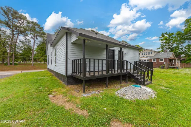 a view of backyard with a garden and deck