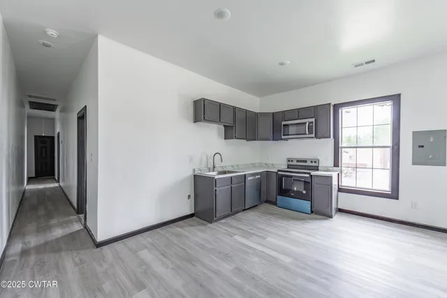 a kitchen with stainless steel appliances granite countertop a stove a sink and a refrigerator